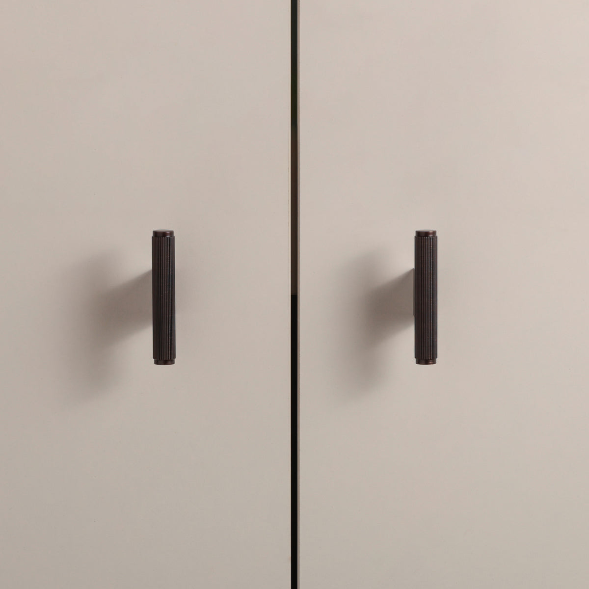 Stripe Knob in Antique Copper Brass installed on cabinet doors
