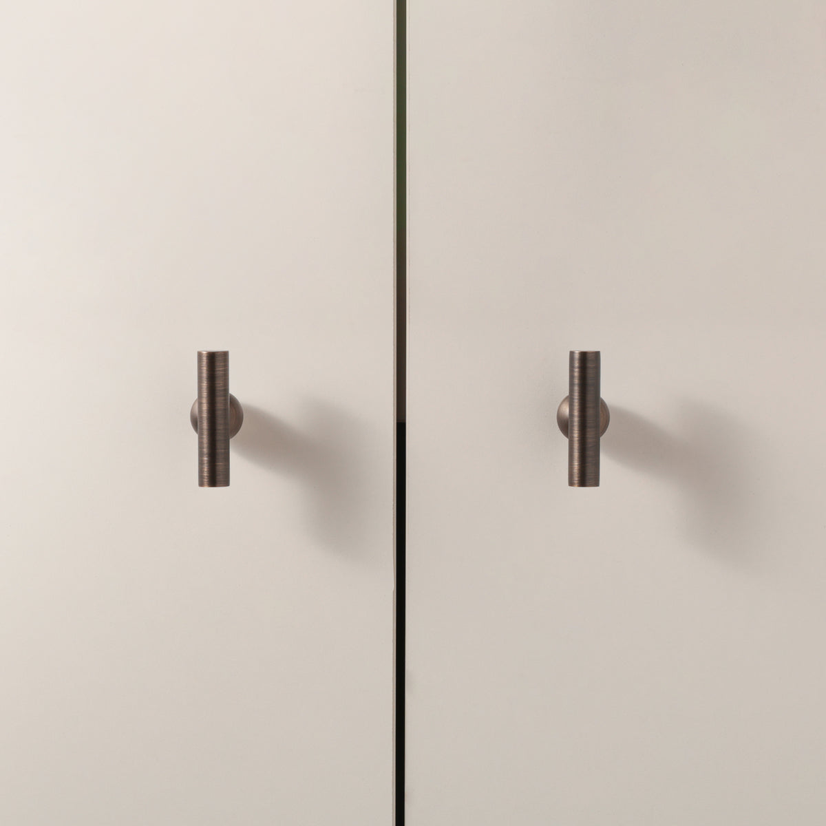 Flair Knob in Antique Brushed Bronze installed on cabinet doors