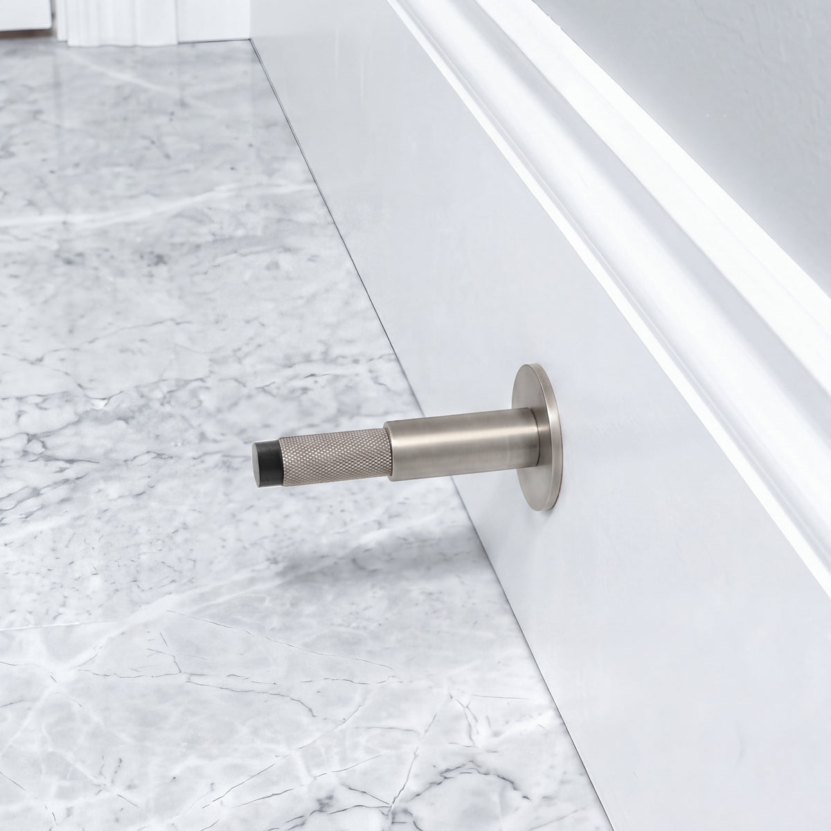 Halo Door Stop in Matte Satin Nickel installed on a marble floor
