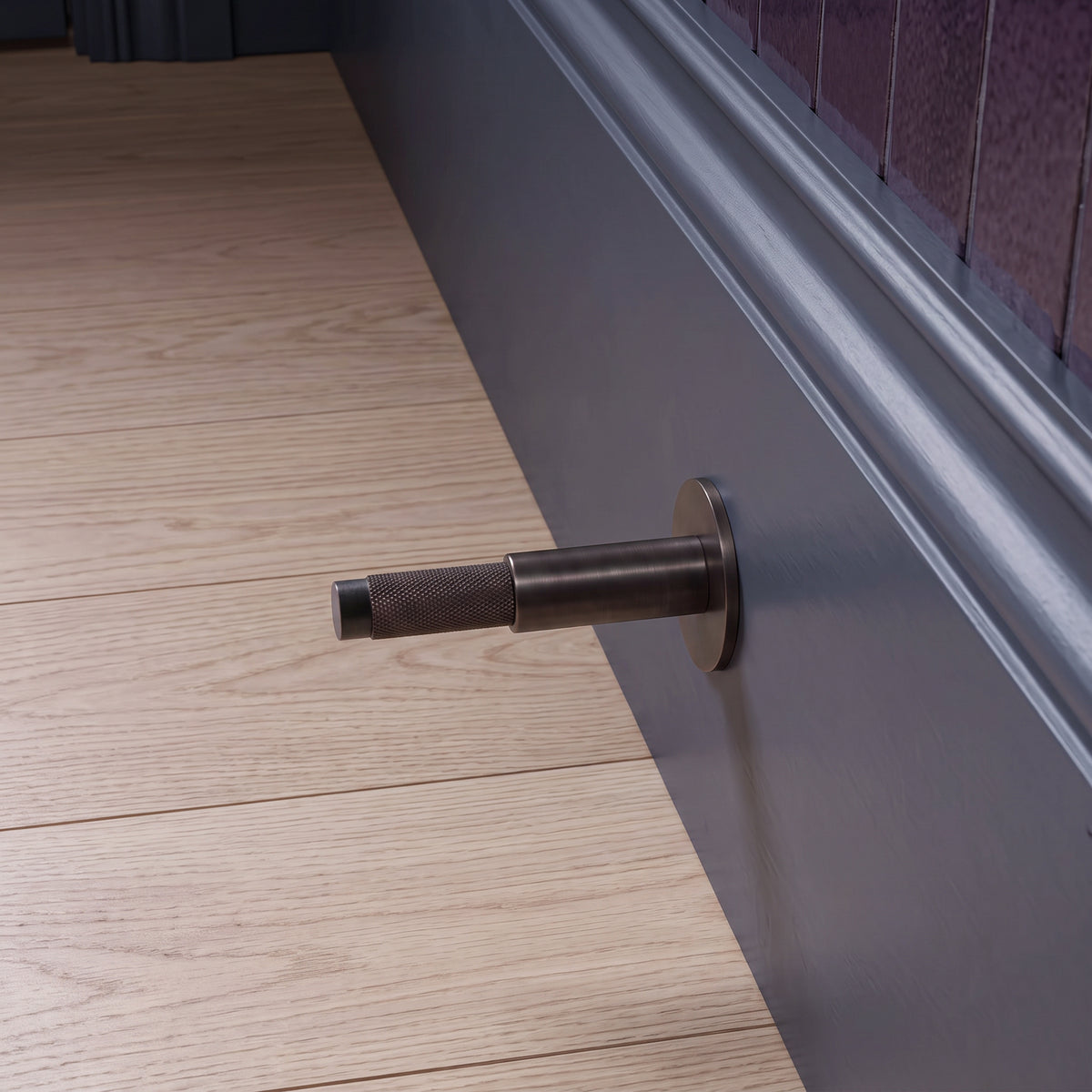 Halo Door Stop in Antique Copper Brass installed on a timber floor